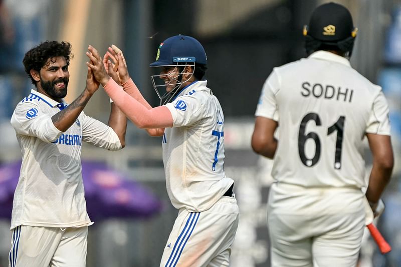 India’s Ravindra Jadeja (L) celebrates with teammate Shubman Gill (C) after taking the wicket of New Zealand’s Ish Sodhi (R) during the first day of the third Test cricket match between India and New Zealand at the Wankhede Stadium in Mumbai on 1 November 2024