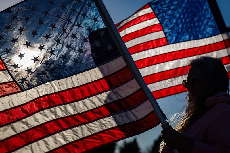 Supporters of former President and Republican presidential nominee Donald Trump gather along William Penn Highway to wave pro-Trump and American flags during rush hour in Easton, Pennsylvania on November 1, 2024