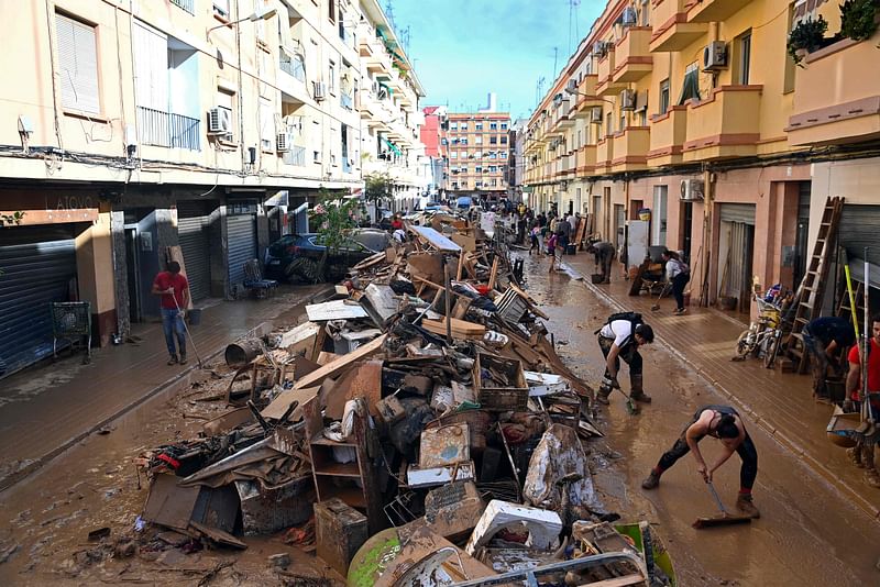 Debris are piled up along a street on 1 November, 2024, following the devastating effects of flooding on the town of Paiporta, in the region of Valencia, eastern Spain.