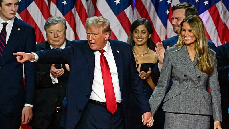 Former US President and Republican presidential candidate Donald Trump gestures at supporters after speaking as he holds hands with former US First Lady Melania Trump during an election night event at the West Palm Beach Convention Center in West Palm Beach, Florida, early on 6 November, 2024