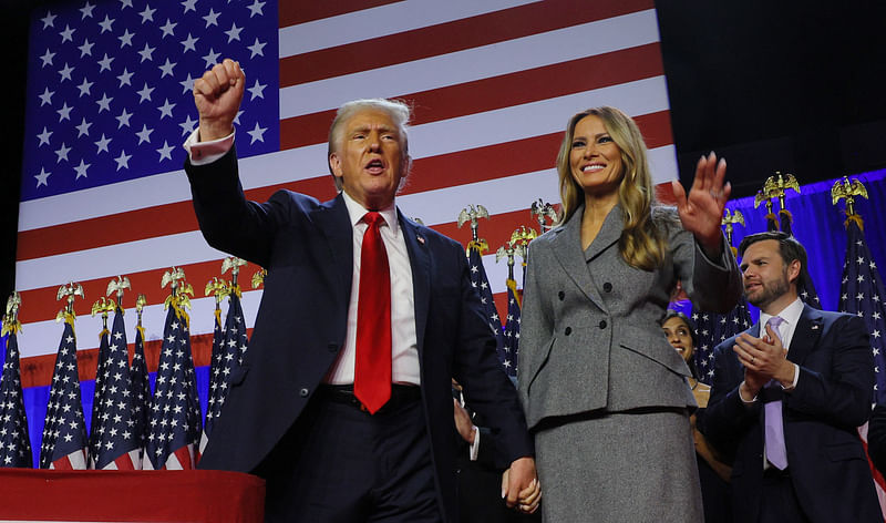 Republican presidential nominee and former US President Donald Trump pumps his fist while accompanied by his wife Melania at his rally, at the Palm Beach County Convention Center in West Palm Beach, Florida, US, on 6 November 2024