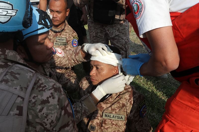 A rescuer and a member of the Malaysian battalion of the United Nations Interim Force In Lebanon (UNIFIL) treat the wound of a fellow soldier, after he was injured at the site of an Israeli airstrike at the northern entrance of the southern Lebanese city of Sidon, on November 7, 2024