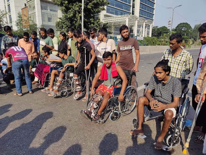 The injured persons on wheel chairs with bandages on their hands, legs and eyes blocked the road in front of the hospital.