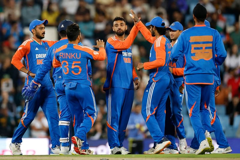 India's Varun Chakravarthy (C) celebrates with teammates after India's Sanju Samson (unseen) stumped out South Africa's Reeza Hendricks (unseen) from a ball he delivered during the third T20 international cricket match between South Africa and India at SuperSport Park in Centurion on 23 November, 2024