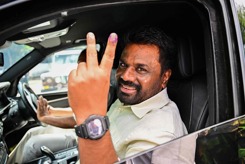 Sri Lankan President Anura Kumara Dissanayake shows his inked finger as he leaves a polling station after casting his ballot to vote in Sri Lanka's parliamentary election in Colombo on 14 November, 2024