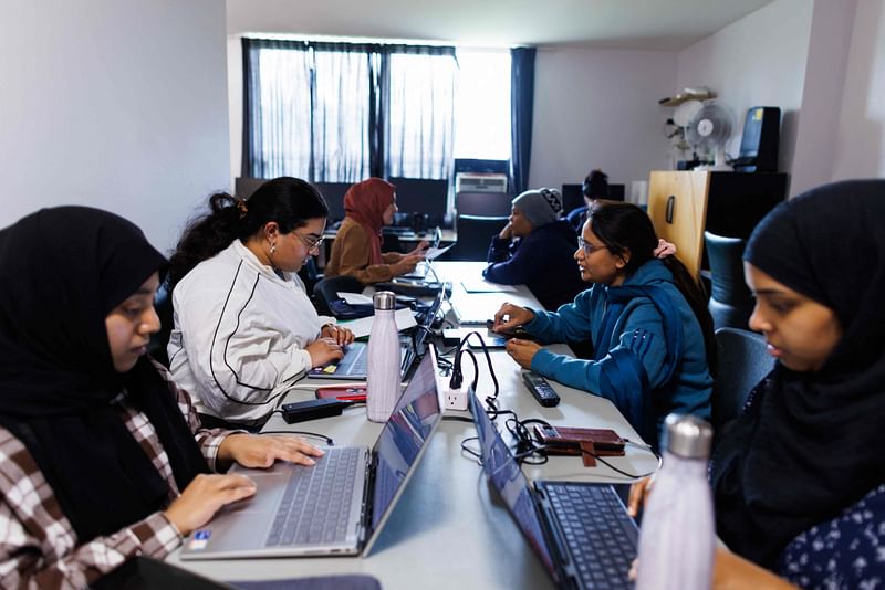 Peer support worker Maesha Afroz (2nd L) works with client Aysha Begum at the South Asian Women’s Rights Organisation, in Toronto, Canada, on 30 October 2024