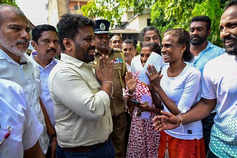 Sri Lankan President Anura Kumara Dissanayake (3L) leaves a polling station after casting his ballot to vote in Sri Lanka's parliamentary election in Colombo on 14 November, 2024