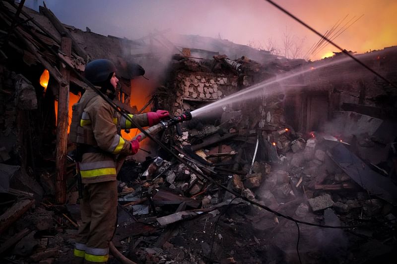 In this handout photograph taken and released by the Ukrainian Emergency Service on 17 November, 2024, a Ukrainian rescuer works to extinguish a fire in a building following a drone attack in Mykolaiv. Ukraine's energy operator DTEK on 17 November, 2024 announced "emergency power cuts" in the Kyiv region and two others in the east after authorities revealed Russia had launched a "massive" aerial attack on the energy grid.