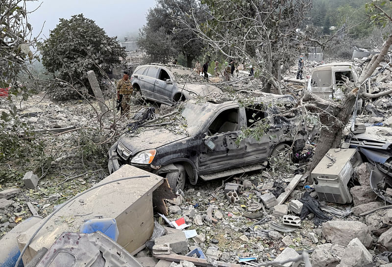 Lebanese army soldier stands near destroyed vehicles at a site damaged by an Israeli air strike in the Christian-majority region of Aitou in north Lebanon, the Lebanese health ministry said, on 14 October 2024