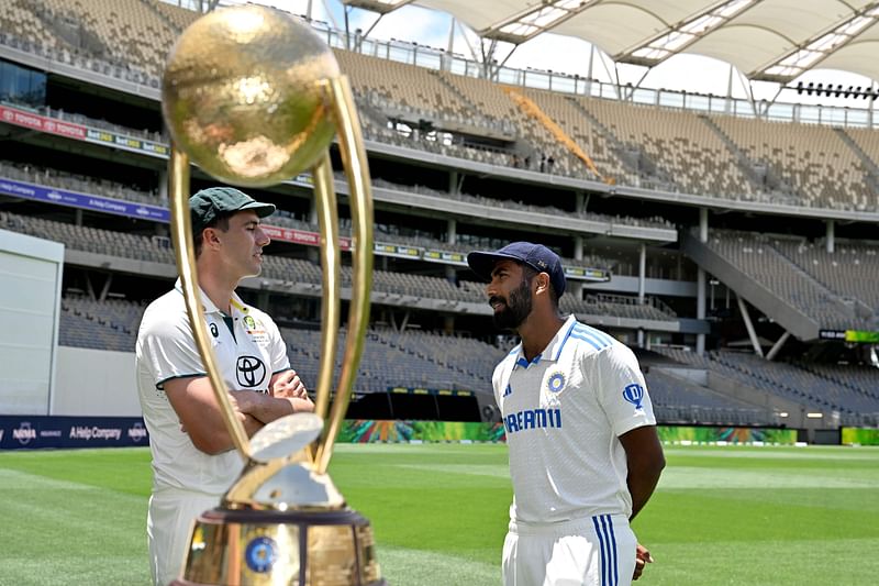 Australia’s captain Pat Cummins (L) talks with India’s captain Jasprit Bumrah after posing with the trophy at Optus Stadium in Perth on 21 November, 2024, ahead of the first cricket Test between Australia and India