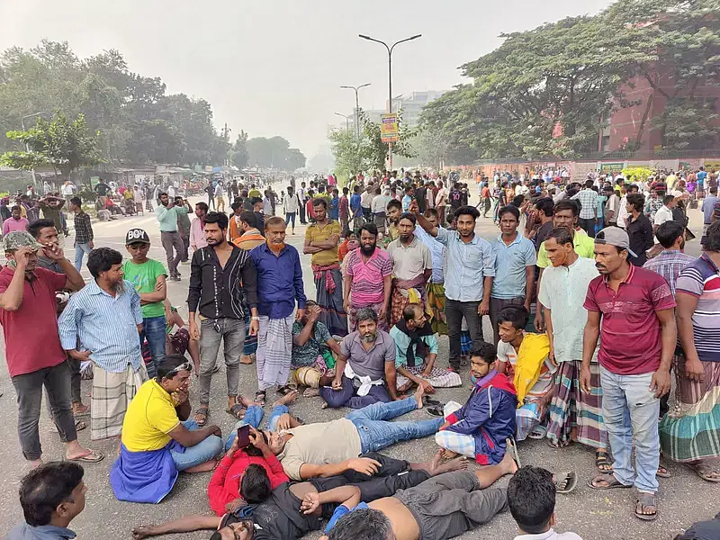 Battery-run rickshaw drivers demonstrate lying down in the middle of the road in Agaorgaon area of Dhaka on 25 November 2024.