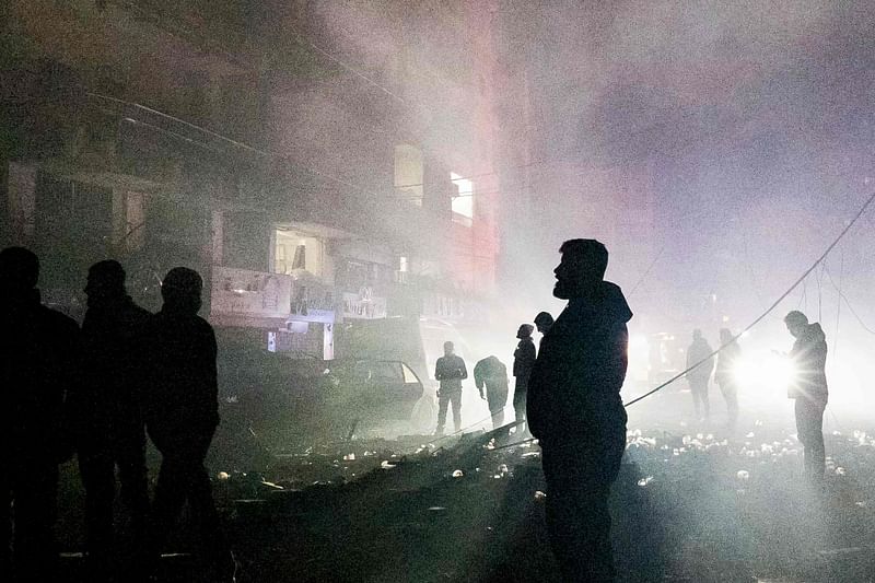 People stand surrounded by smoke at the site of an Israeli airstrike that targeted a neighbourhood in Tyre, southern Lebanon, on 25 November, 2024, amid the ongoing war between Israel and Hezbollah.