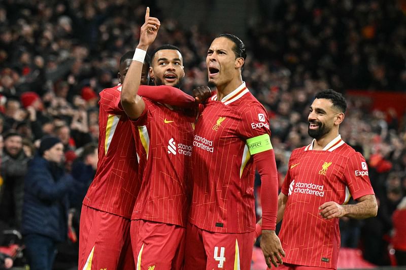 Liverpool's Dutch striker Cody Gakpo (2L) celebrates scoring the team's second goal with Liverpool's Dutch defender Virgil van Dijk during the UEFA Champions League football match between Liverpool and Real Madrid at Anfield in Liverpool on 27 November, 2024