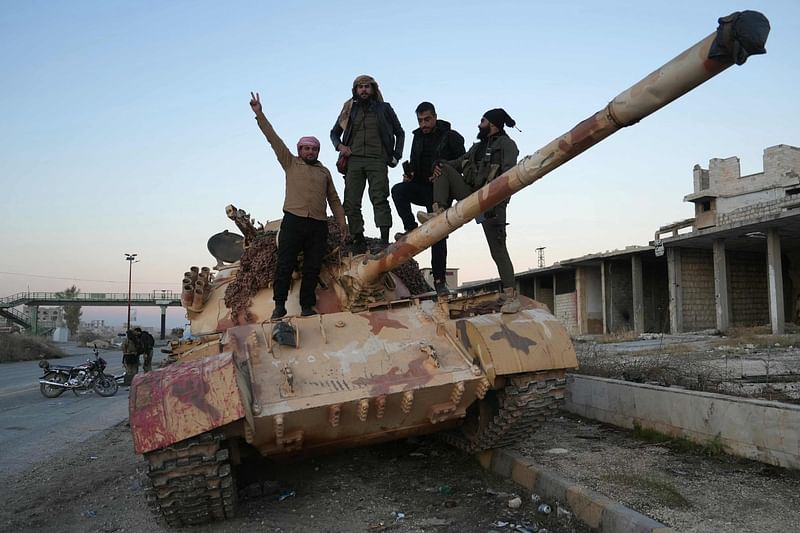 Anti-government fighters pose for a picture on a tank on the road leading to Maaret al-Numan in Syria's northwestern Idlib province on 30 November, 2024. Jihadist-led rebels seized Aleppo airport and dozens of nearby towns on 30 November, after overrunning most of Syria's second city of Aleppo, the Syrian Observatory for Human Rights said.