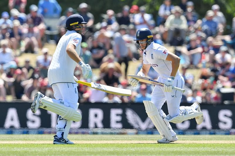 England's Jacob Bethell (R) and Joe Root run between the wickets during the fourth day of the first Test cricket match between New Zealand and England at Hagley Oval in Christchurch on 1 December, 2024.