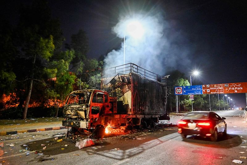 A rally truck used by Bushra Bibi, the wife of Pakistan's former prime minister Imran Khan, burns near the red zone after a protest to demand Khan's release, in Islamabad on November 27, 2024