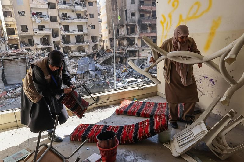 Staff members of the Amel Association, a Lebanese non-governmental organisation, salvage items at their branch that was damaged in an Israeli strike on a nearby building, in Beirut's southern suburbs Hay el-Sellom neighbourhood on December 2, 2024