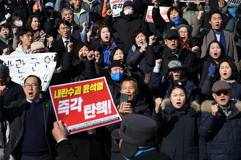 People hold signs during a rally calling for the resignation of South Korean President Yoon Suk Yeol, in Seoul, South Korea, on 4 December 2024