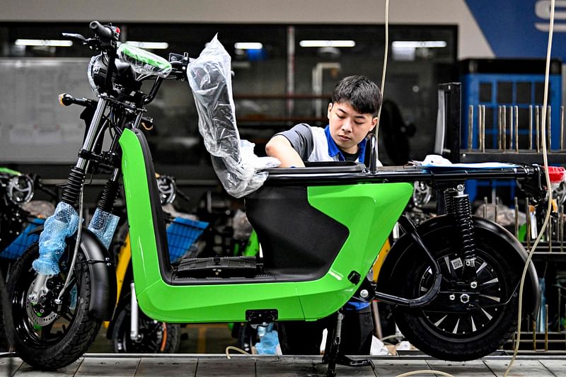 This photo taken on November 7, 2024 shows a worker assembling electric motorbikes at the Selex factory in Hanoi.