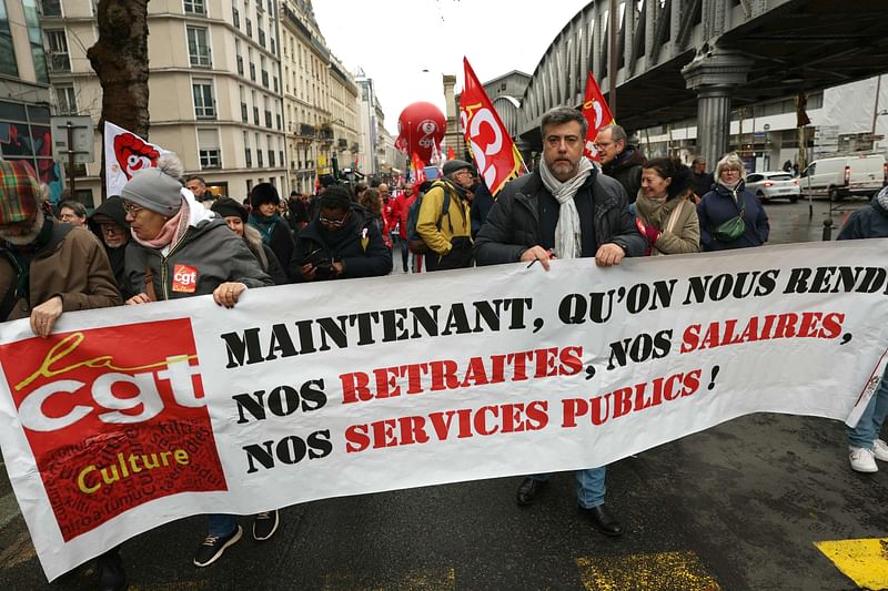 Protesters hold a banner reading "Now, return our pensions, salaries, public services" during a demonstration in Paris on December 5, 2024, as part of a day of action and strike in the public sector. Civil servants in France are mobilizing on December 5, 2024 for a day of action and strikes called by public service unions to open up a social front in the midst of a political crisis, the day after Michel Barnier's government fell on a motion of no-confidence