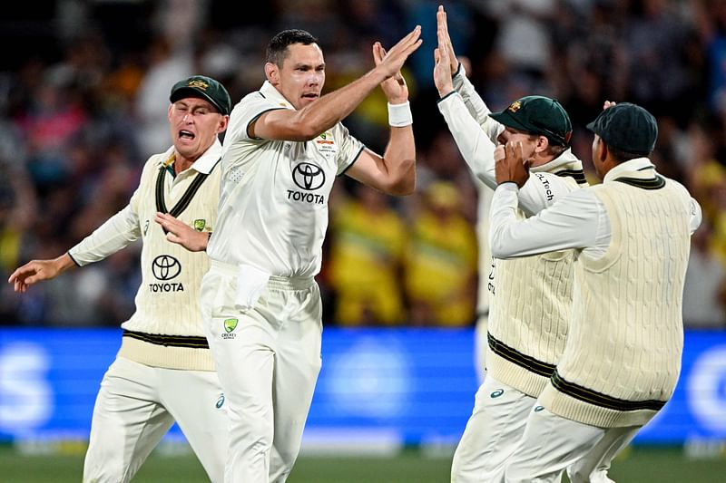 Australian bowler Scott Boland (2L) celebrates with teammates after taking the wicket of Indian batsman Virat Kohli on the second day of the second cricket Test match between Australia and India at the Adelaide Oval in Adelaide on 7 December, 2024.