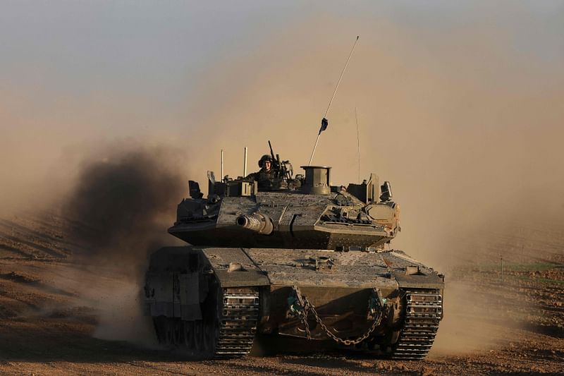 An Israeli soldier sits on the top of army tank near the Israeli border fence with the Gaza Strip, on 10 December 2024, as the war between Israel and Hamas continues in Gaza