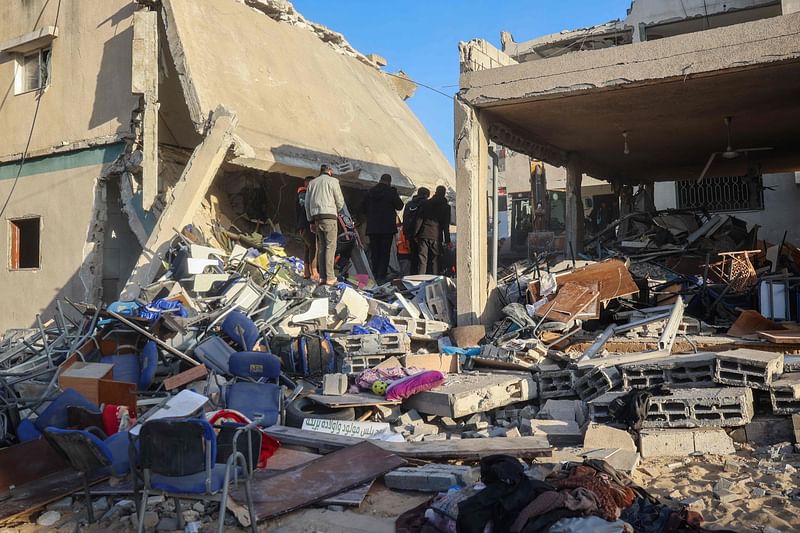 Rescuers and people search building rubble for casualties following an Israeli strike on the municipality building in Deir el-Balah in the central Gaza Strip on December 14, 2024, as the war continues between Israel and the Palestinian Hamas group