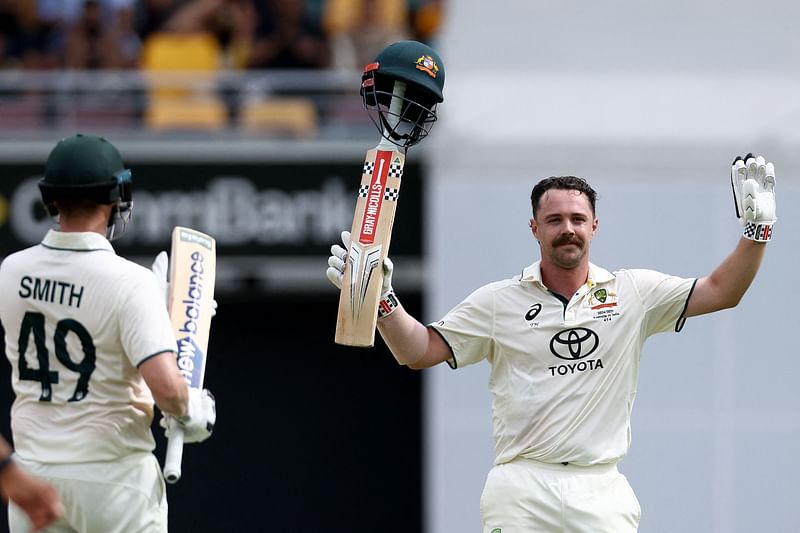 Australia's Travis Head (R) celebrates reaching his century with teammate Steve smith on day two of the third cricket Test match between Australia and India at The Gabba in Brisbane on 15 December, 2024.