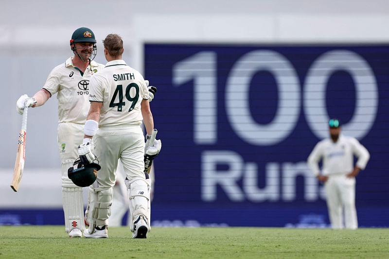 Australia’s Steve Smith (R) celebrates reaching his century with teammate Travis Head on day two of the third cricket Test match between Australia and India at The Gabba in Brisbane on 15 December 2024