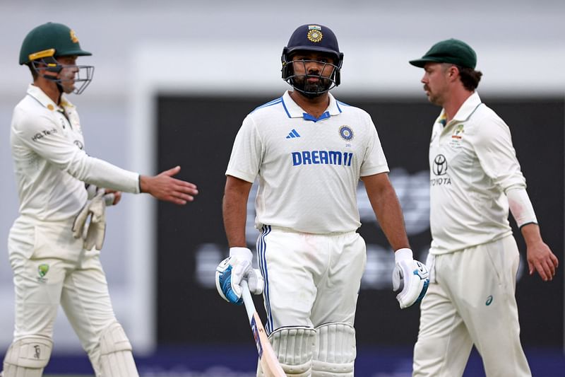 India’s captain Rohit Sharma (C) reacts as he walks off the ground in front of Australia’s Alex Carey (L) and Travis Head due to bad light on day three of the third cricket Test match between Australia and India at The Gabba in Brisbane on 16 December 2024