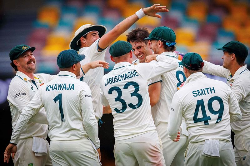 Australia’s captain Pat Cummins (2nd R) celebrates the catch by Mitchell Marsh (R) to dismiss India’s Ravindra Jadeja on day four of the third cricket Test match between Australia and India at The Gabba in Brisbane on 17 December 2024