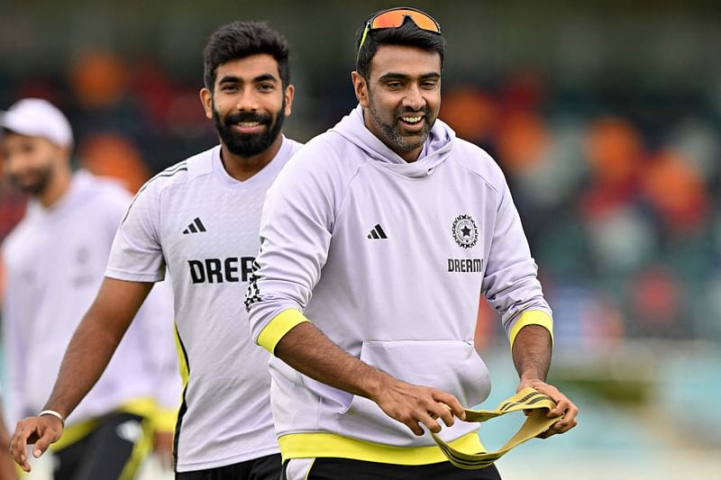 This picture taken on 1 December 2024 shows India’s spin bowler Ravichandran Ashwin (R) attending a cricket warm-up session with teammate Jasprit Bumrah at Manuka Oval in Canberra. Ashwin announced his immediate retirement from international cricket following the third Test against Australia in Brisbane on 18 December 2024