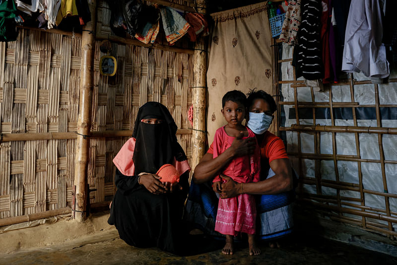 Rahimullah, 27, and wife Juhara Begum, 25, pose with their child at a refugee camp near the town of Cox’s Bazar, Bangladesh, on 22 November 2024