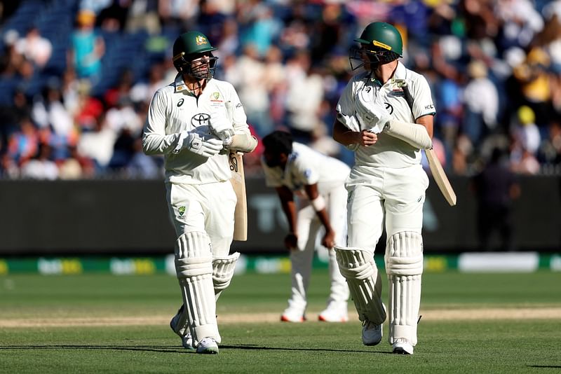 Australia’s Nathan Lyon (L) and Scott Boland leave the field at the close of play on day four of the fourth cricket Test match between Australia and India at the Melbourne Cricket Ground (MCG) in Melbourne on 29 December 2024