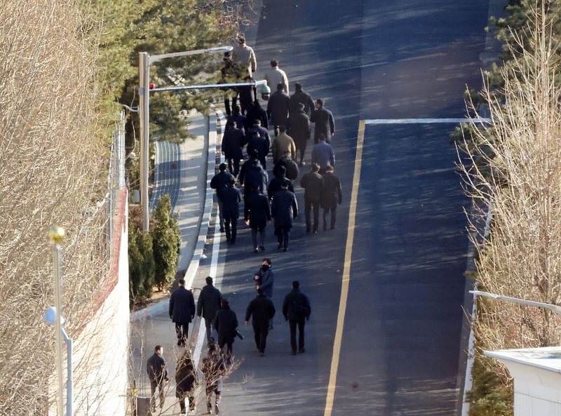 Anti-corruption investigators walk up a hill inside the presidential residence of impeached South Korea President Yoon Suk Yeol in Seoul on 3 January, 2025