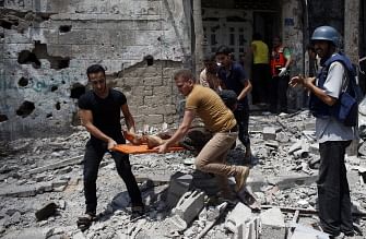 Palestinian medics evacuate a body from a site damaged in Israeli strike.