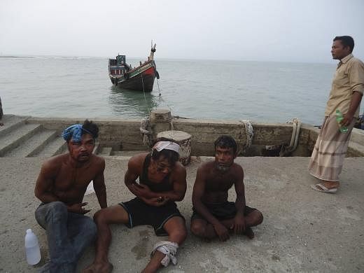 Injured suspected human trafficking victims rest after the Thai trawler they were on was rescued by the Bangladesh Coast Guard, in southern Bangladesh on June 11, 2014, in this handout picture provided by the Bangladesh Coast Guard