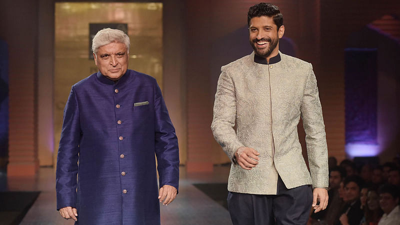 Indian Bollywood lyricist and scriptwriter Javed Akhtar (L) and his son, Bollywood actor Farhan Akhtar, model creations by designer Manish Malhotra during a charity fashion show in Mumbai on late on 4 April, 2015. Photo: AFP