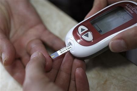 A health worker checks diabetes of a person