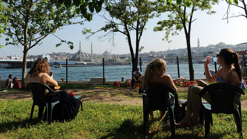 Tourists sitting in the sun in the Karakoy neighborhood of Istanbul