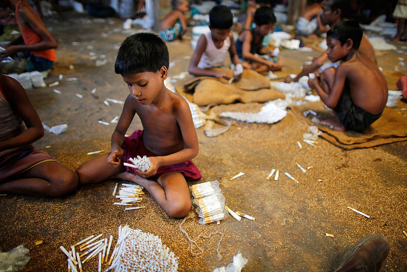 Children fill up empty cigarettes with locally grown tobacco in a factory at Haragach in Rangpur district, Bangladesh