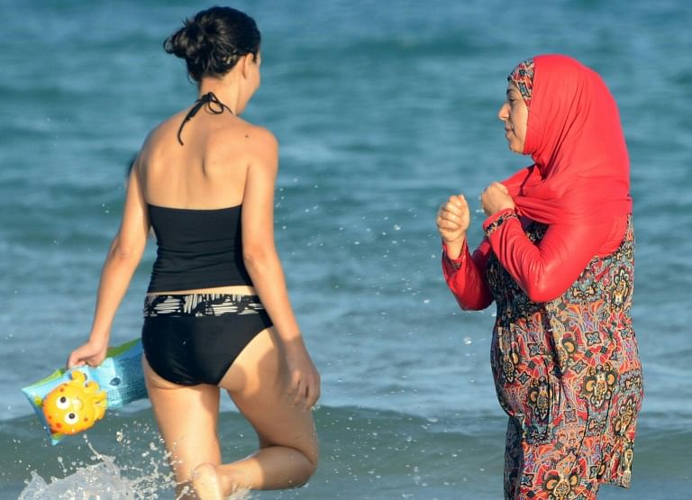 A French court said local authorities could only introduce measures restricting individual freedoms if wearing the burkini (pictured, R) on beaches represented a “proven risk” to public order.