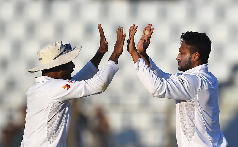 Bangladesh Shakib Al Hasan (R) and teammate Imrul Kayes celebrate the wicket of England's Ben Stokes during the third day of the first Test match between Bangladesh and England at Zahur Ahmed Chowdhury Cricket Stadium in Chittagong on 22 October, 2016