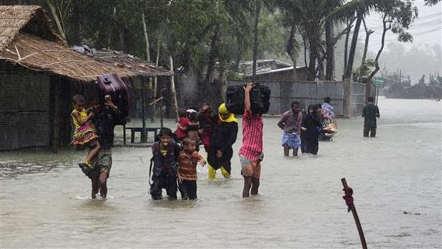 People looking for a shelter in knee-deep floodwater