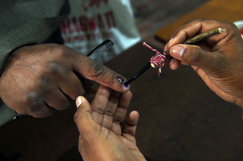 An Indian election officer marks the finger of a voter at a polling station in Muzaffarnagar in Uttar Pradesh