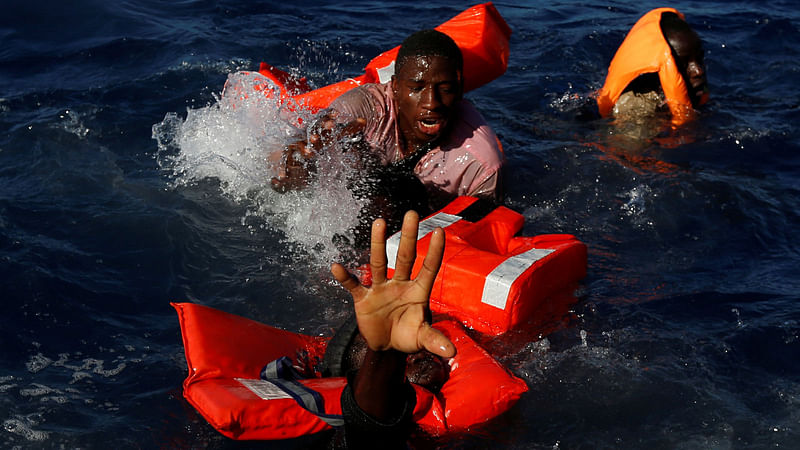 Migrants try to stay afloat after falling off their rubber dinghy during a rescue operation by the Malta-based NGO Migrant Offshore Aid Station (MOAS) ship in the central Mediterranean in international waters some 15 nautical miles off the coast of Zawiya in Libya, April 14, 2017.