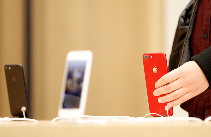 A person holds a red iPhone product at a Apple store in Nanjing.