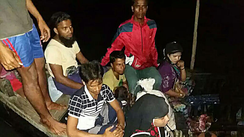 Rohingya refugees fleeing from Myanmar sitting in a boat after Bangladesh coast guard stopped them on Naf river from entering the country.