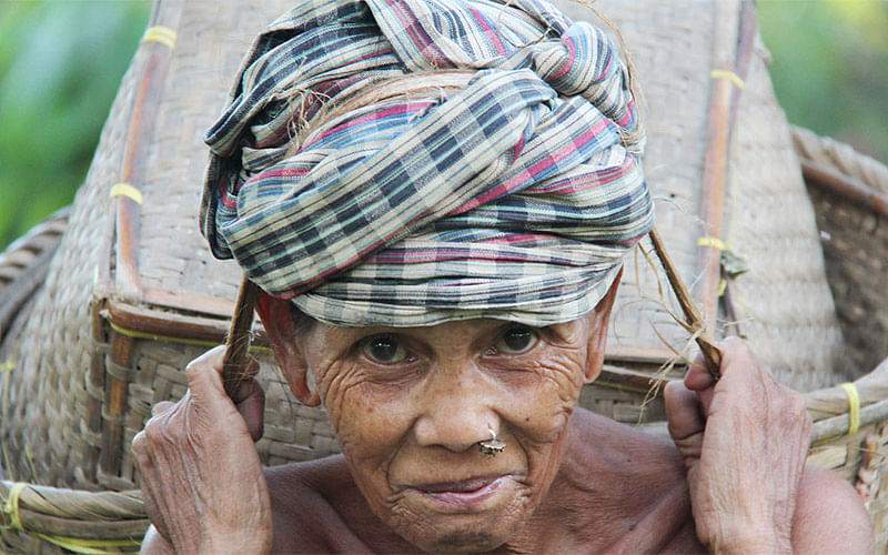 An elderly ethnic woman returning home after collecting paddy from the jhum fields in Simanapara area of Dighinala upazila in Khagrachhari