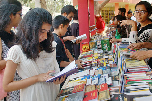 A child browses a book at a stall at Amar Ekushey Grantha Mela